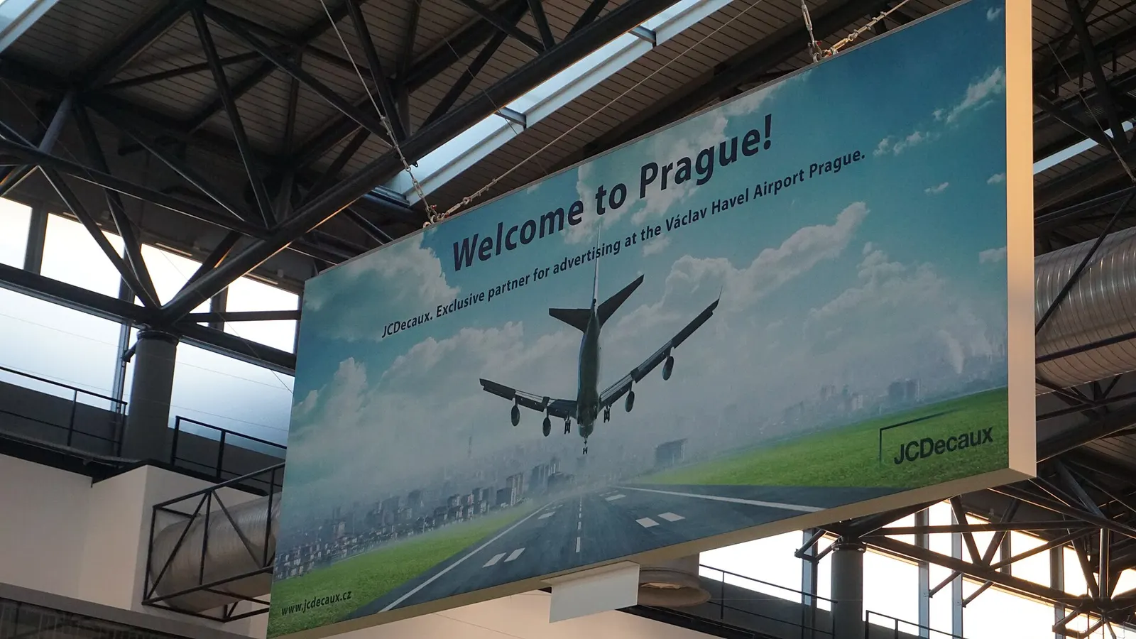 A large welcome sign reading a greeting to the Czech Republic mounted in the Terminal 2 area of Václav Havel Airport Prague.