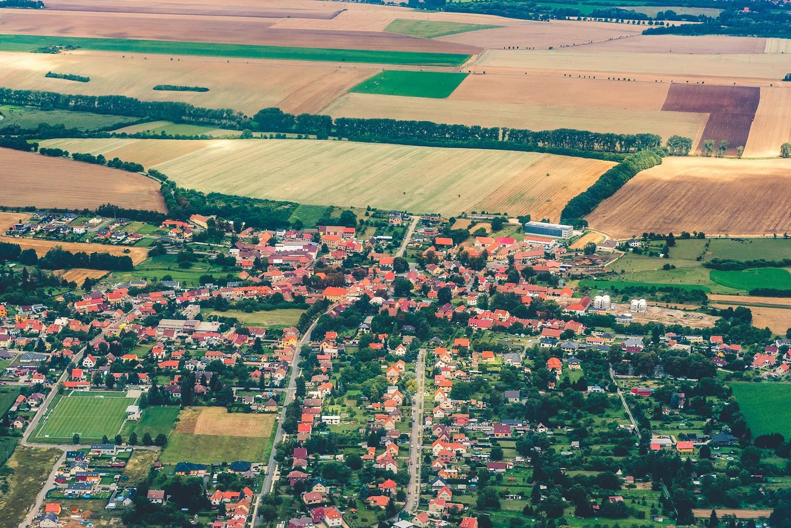 Aerial photograph looking down on Václav Havel Airport Prague, showing runways, terminal buildings, and surrounding countryside west of the city.