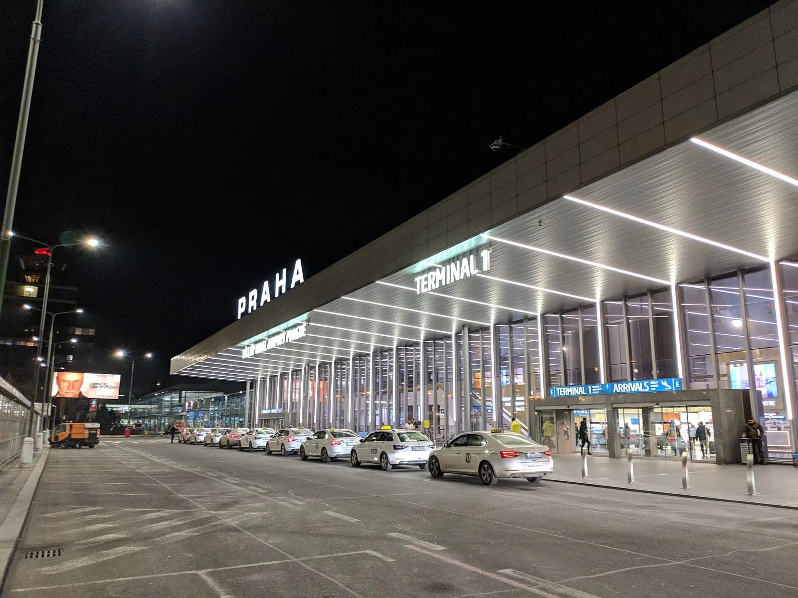 The glass-fronted arrivals facade of Terminal 1 at Václav Havel Airport Prague, seen from outside at street level.