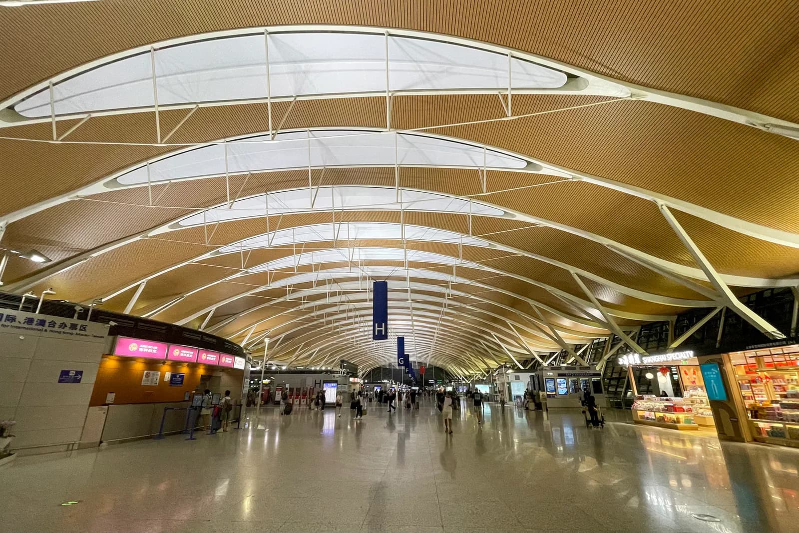 Long departure concourse in Terminal 2 with gate seating areas, flight information displays, and floor-to-ceiling windows.