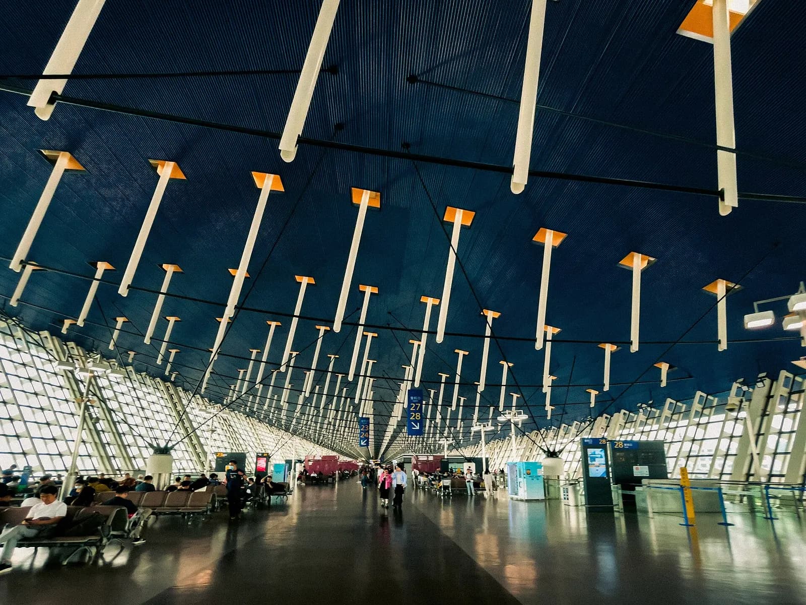 Exterior of Terminal 1 departures level showing the distinctive roofline, roadway drop-off, and entrance canopies.