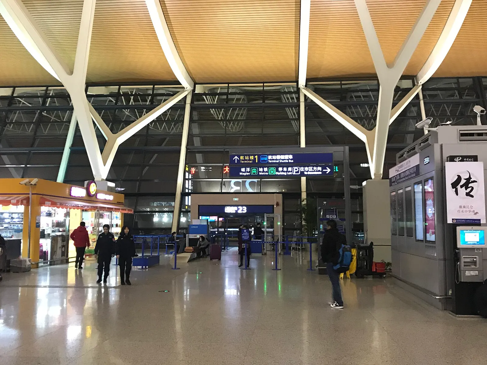 Passengers queuing at the pre-security document check area in Terminal 2 of Shanghai Pudong Airport.