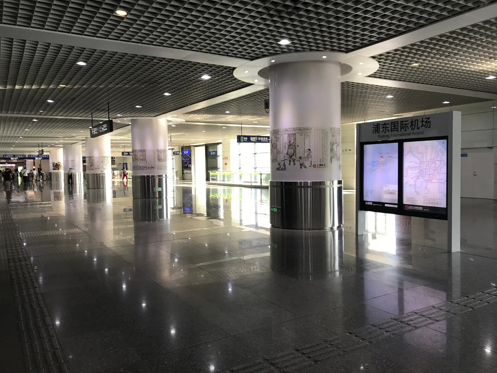 Underground concourse of the Shanghai Metro Line 2 station at Pudong International Airport with ticket gates and signage.