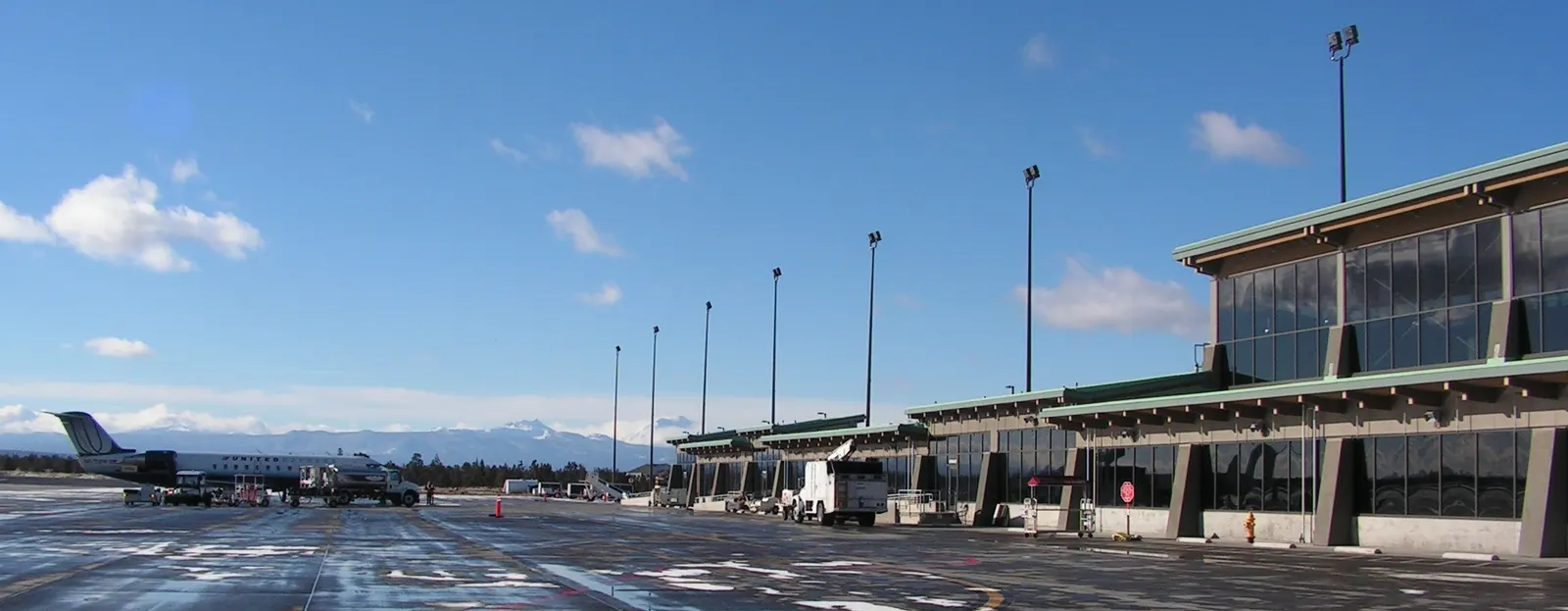 Historic December 2010 view of the Redmond Municipal Airport passenger terminal and ramp with the Cascade Range beyond.
