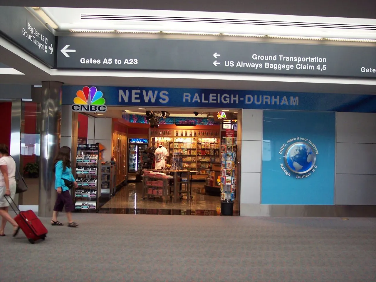 The CNBC News Store retail shop inside RDU, with shelves of magazines, snacks, and travel goods under store signage.