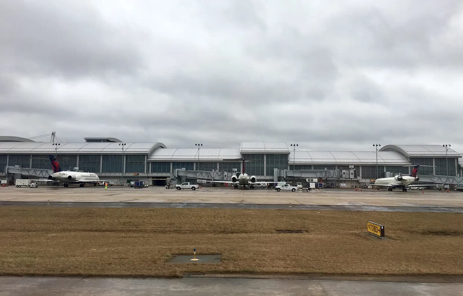 Concourse D at RDU seen from the terminal, with three Delta Air Lines jets parked at gates along the ramp.