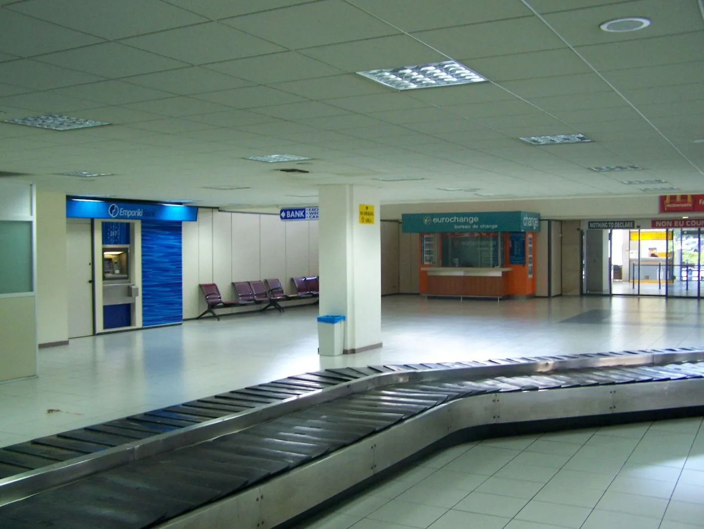 Arrivals area signage and passenger flow at Rhodes Diagoras Airport.