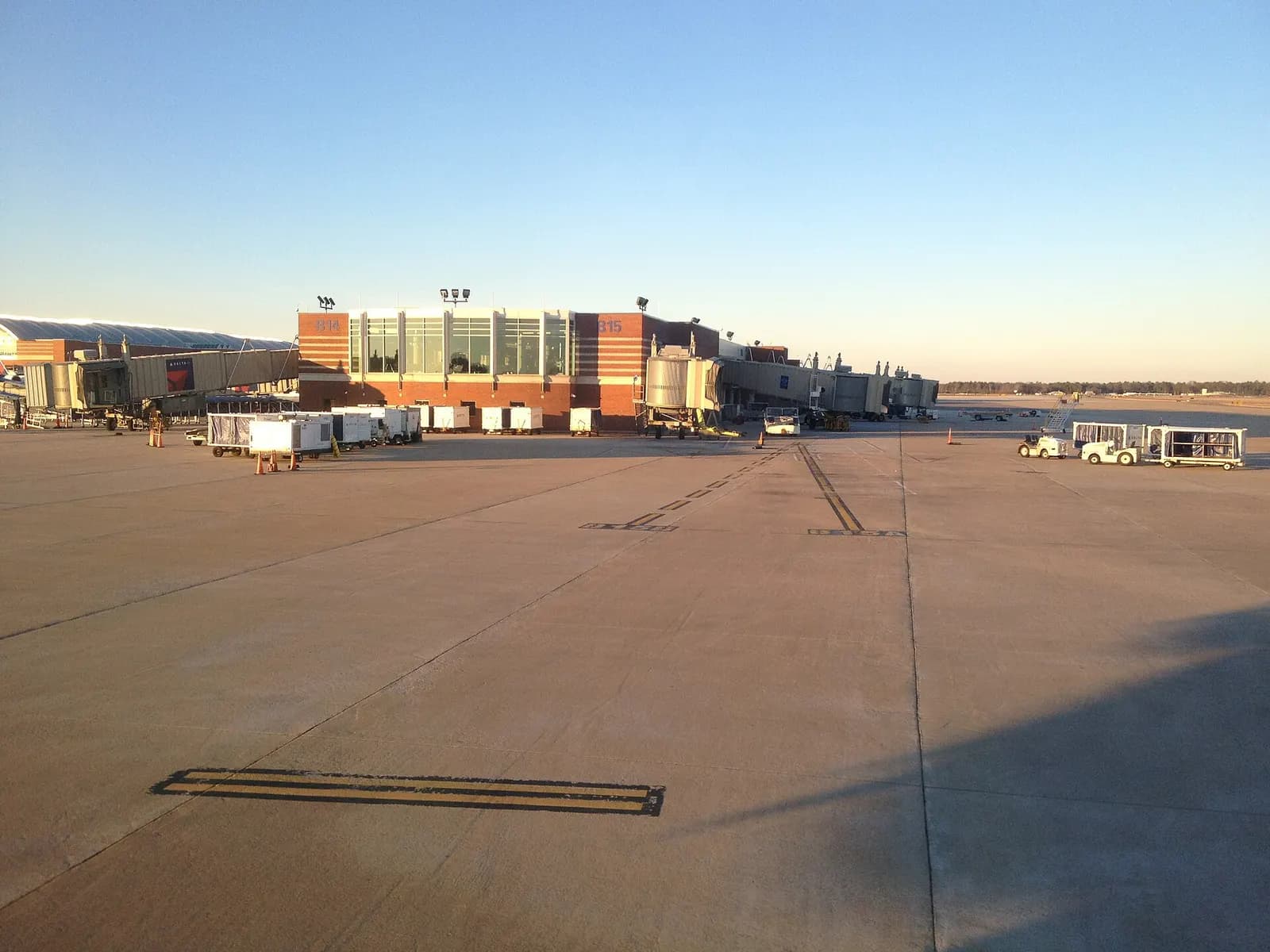 Empty ramp in front of Richmond International Airport gates B14 and B15 with jet bridges at golden hour.