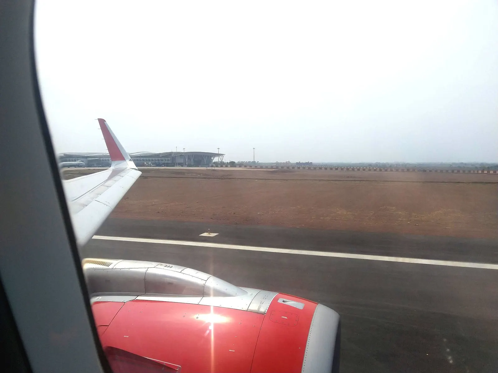 This image shows the terminal and Airfield view from Runway of Raipur Airport, This picture was taken from an Air India Aircraft which was on its way to departure.