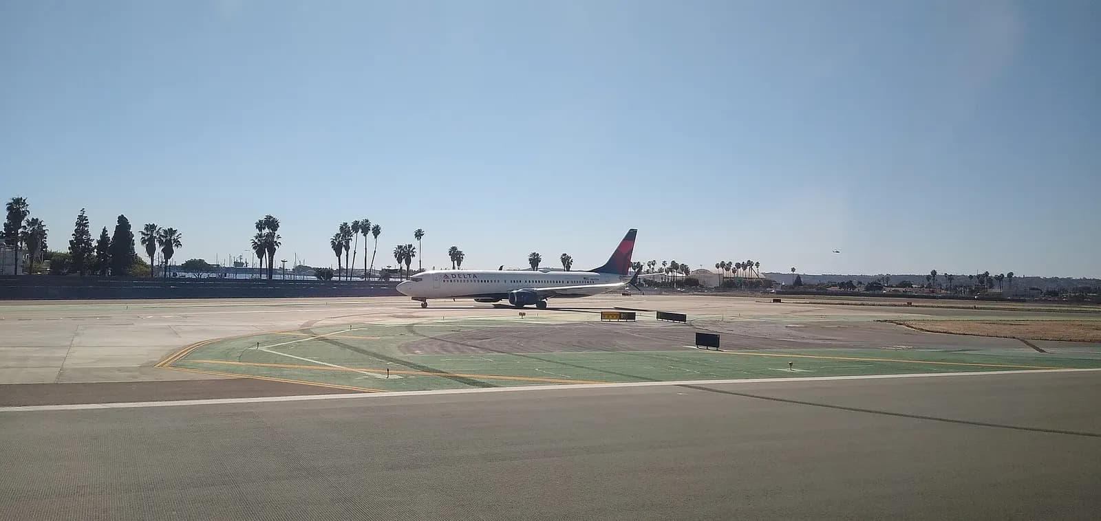 Boeing 737-9 N831DN operated by Delta Airlines waiting on taxiway at San Diego International Airport before takeoff.