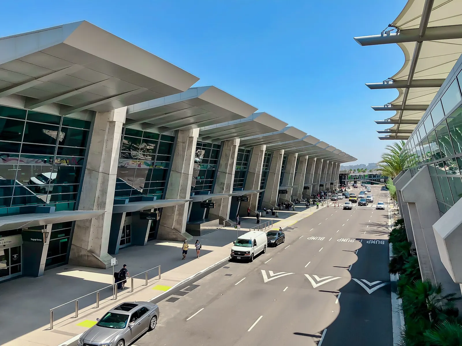 A view from Terminal 2's upper departure level looking down at the arrivals curb, roadway, and terminal facade.