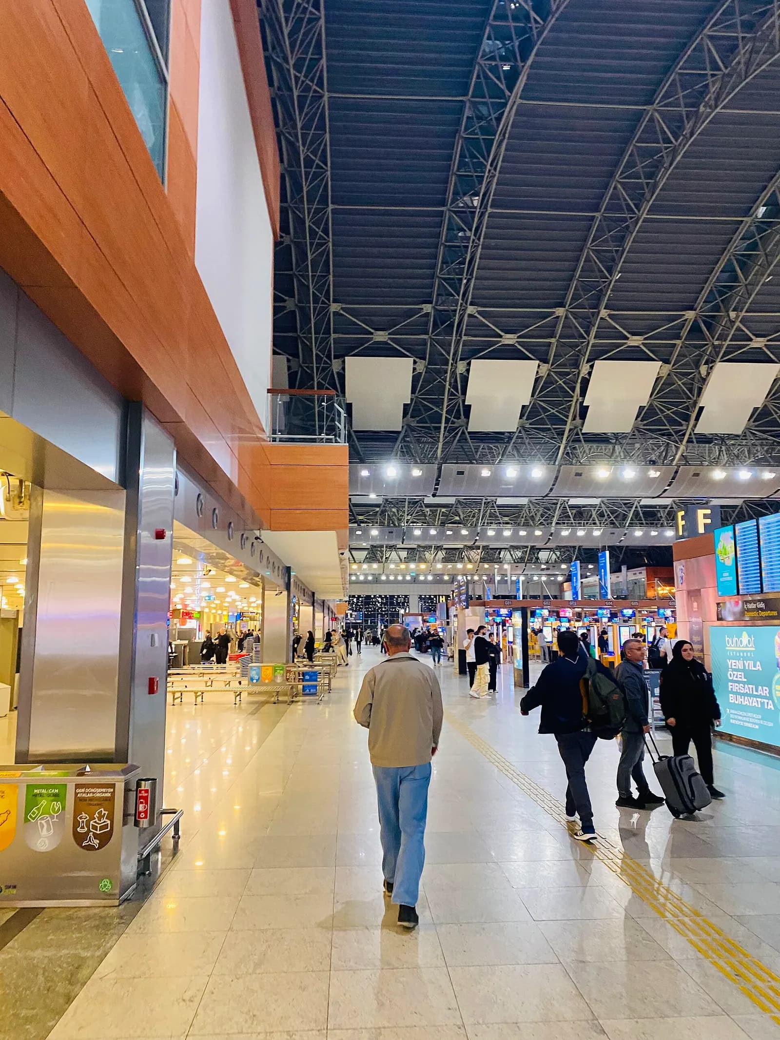 Rows of airline check-in counters with overhead signage in the departures hall at Sabiha Gökçen Airport.