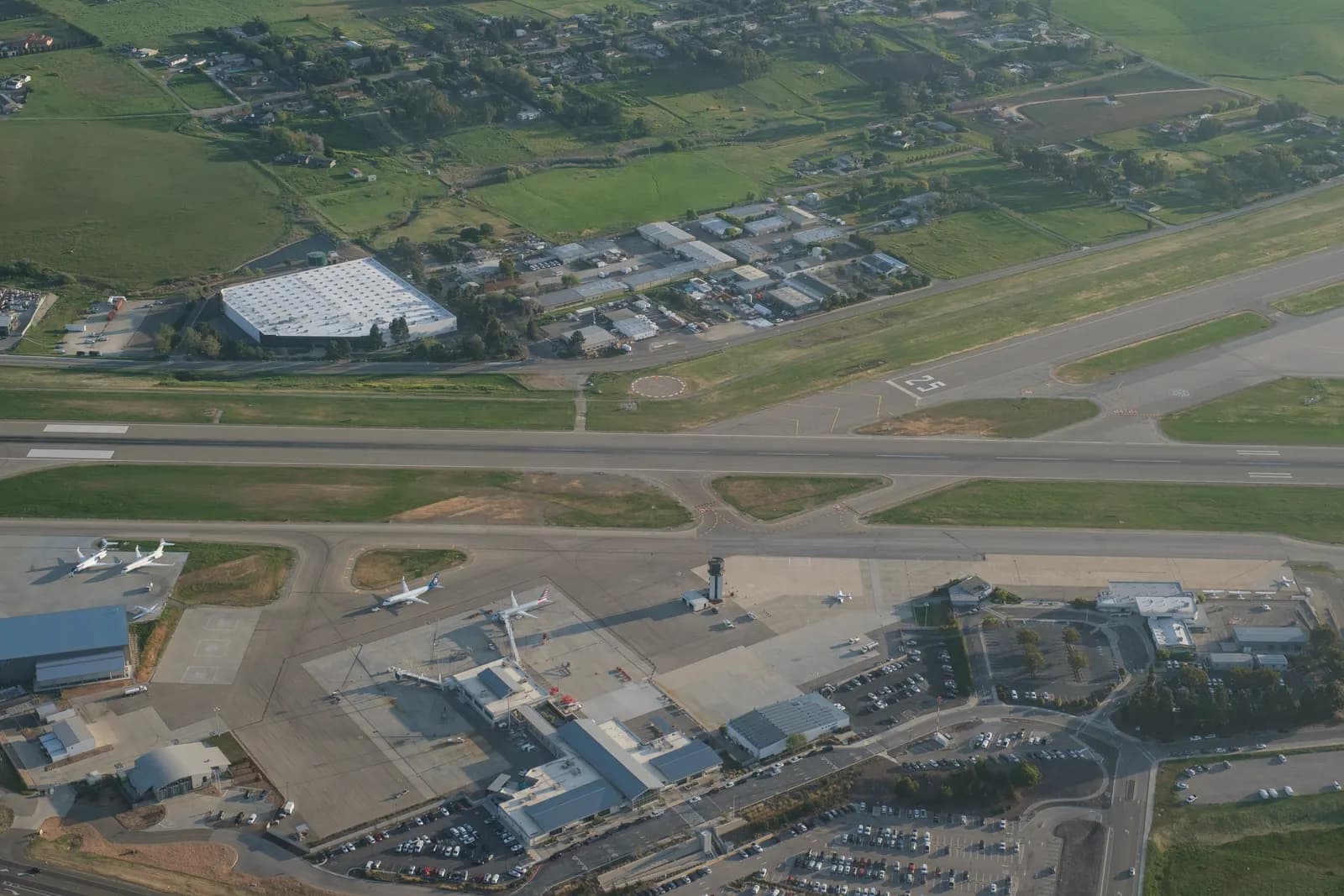 Aerial view of San Luis Obispo County Regional Airport with the 2017 passenger terminal on the left and the older terminal on the right