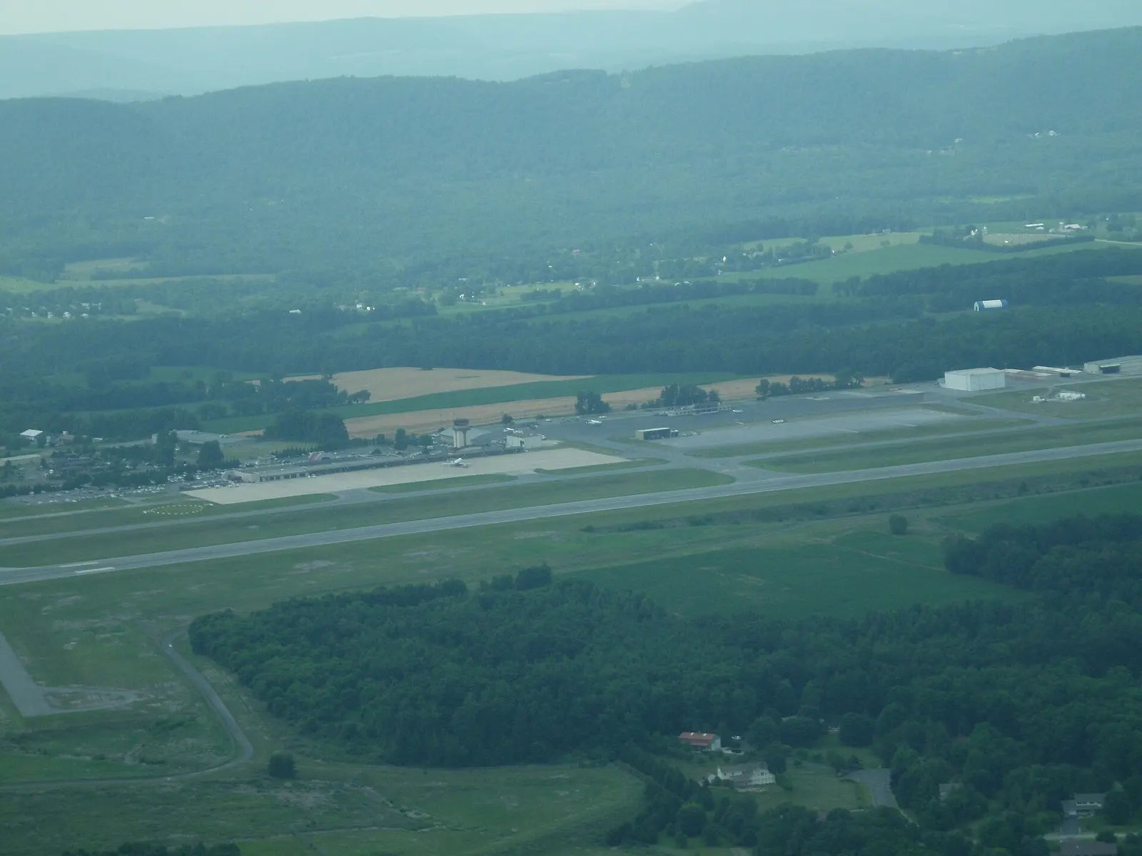 Aerial view of State College Regional Airport from downwind, showing the single runway and commercial ramp