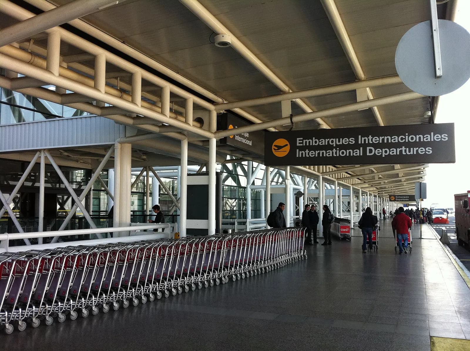 The airport terminal building, access road, and outdoor drop-off area photographed from outside.