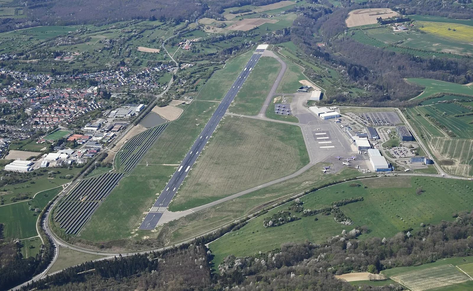 Aerial overview of Saarbrücken Airport runway, apron, and terminal campus.