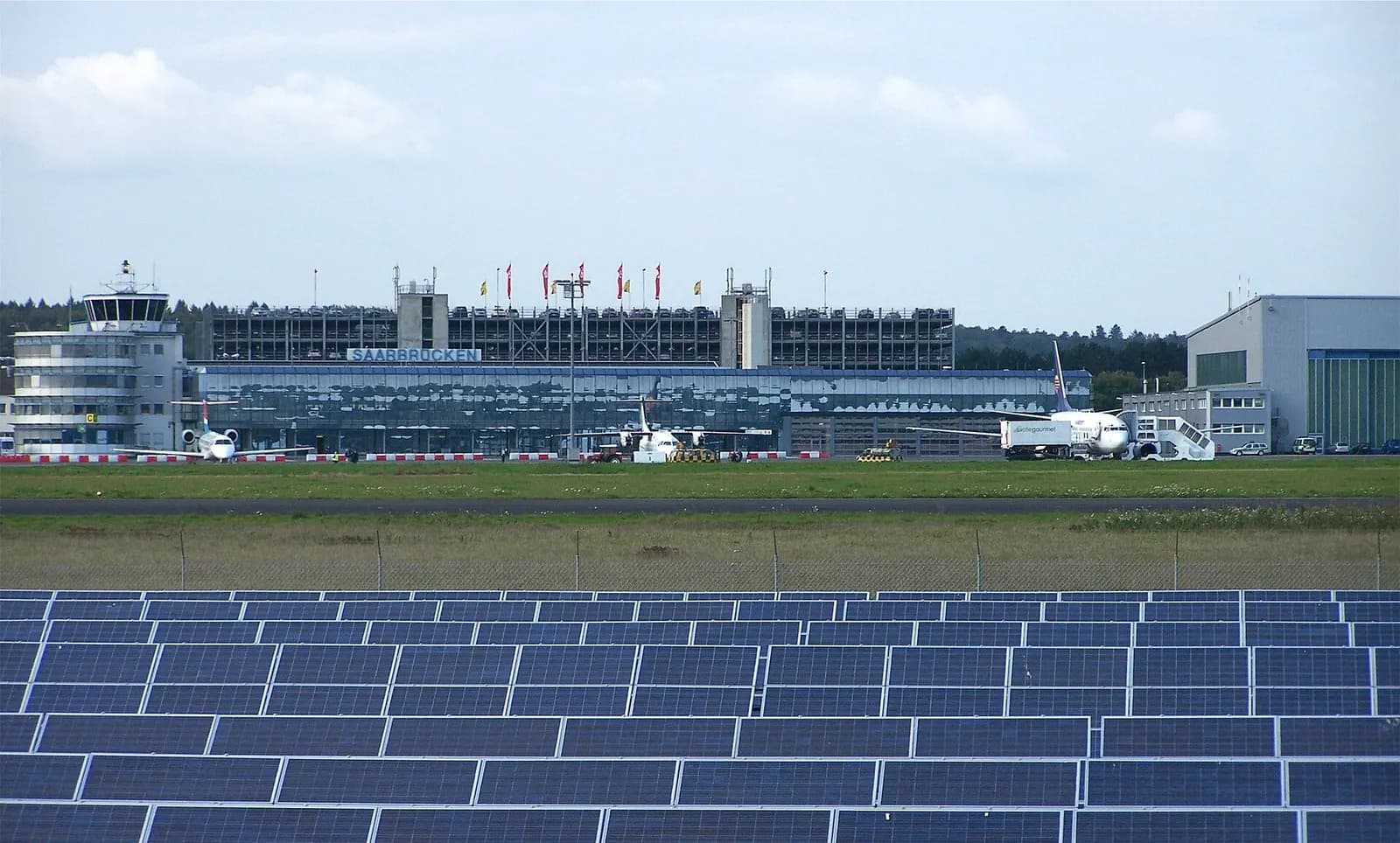 Saarbrücken Airport terminal with rooftop solar array visible.