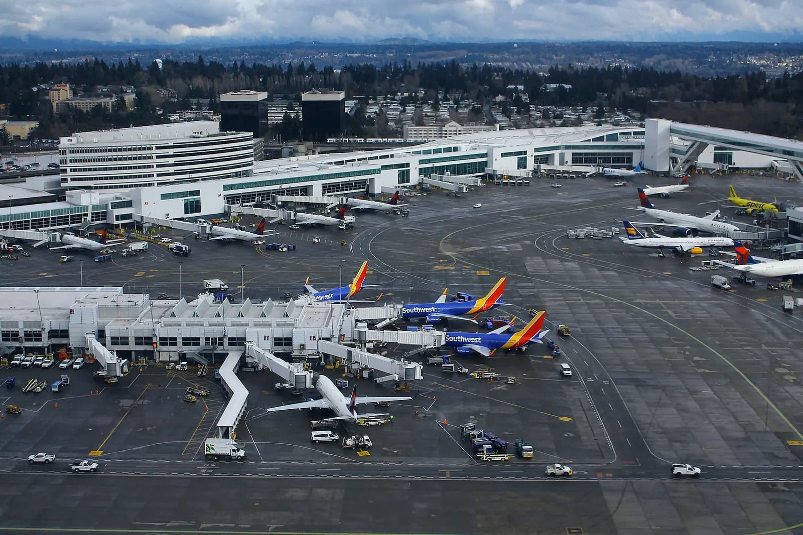 An aerial view looking down on Sea-Tac's Terminals A and B, showing concourses, gates, and surrounding taxiways.
