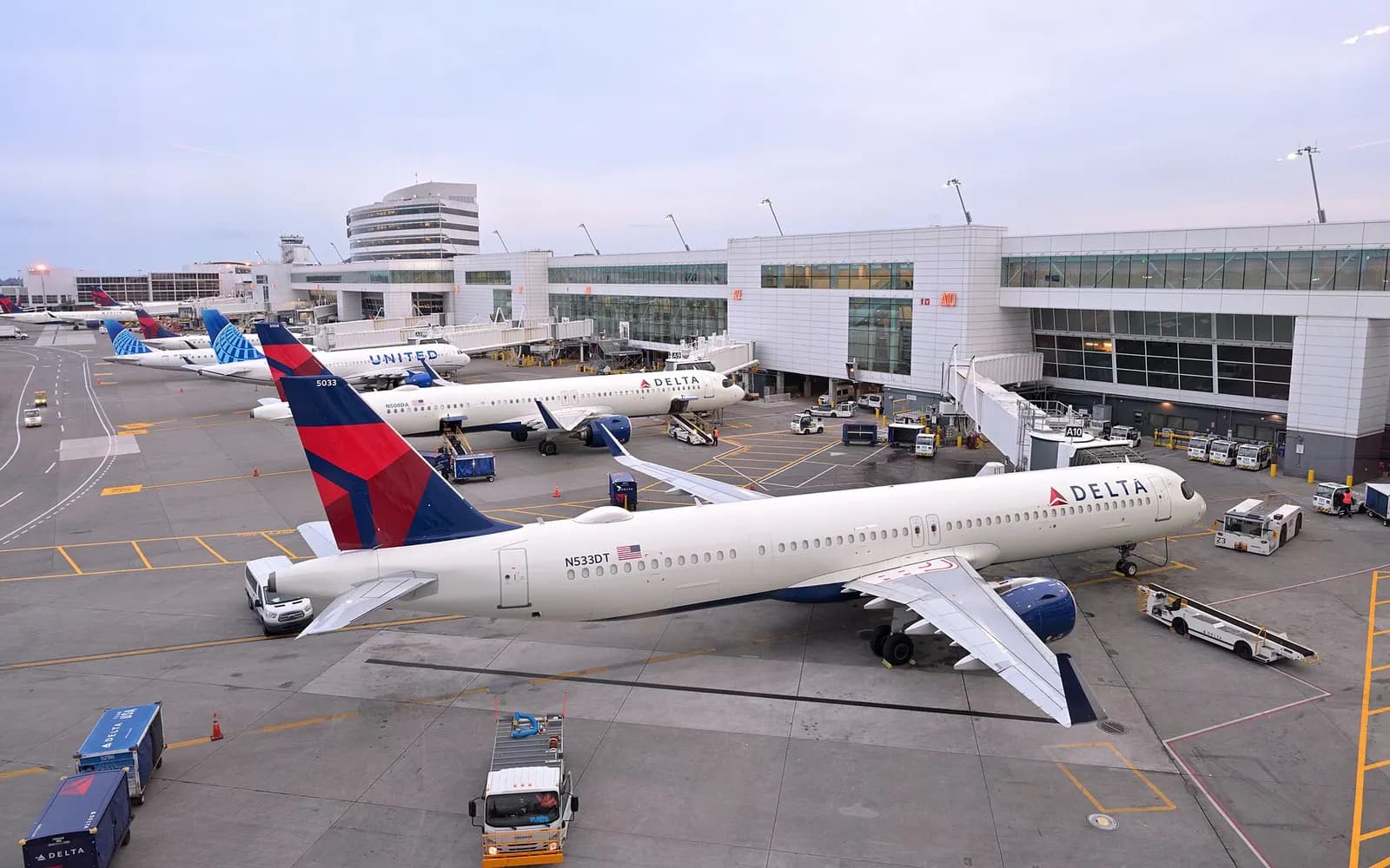 Multiple airliners parked at gates along the S concourse, viewed from the pedestrian bridge above the ramp.
