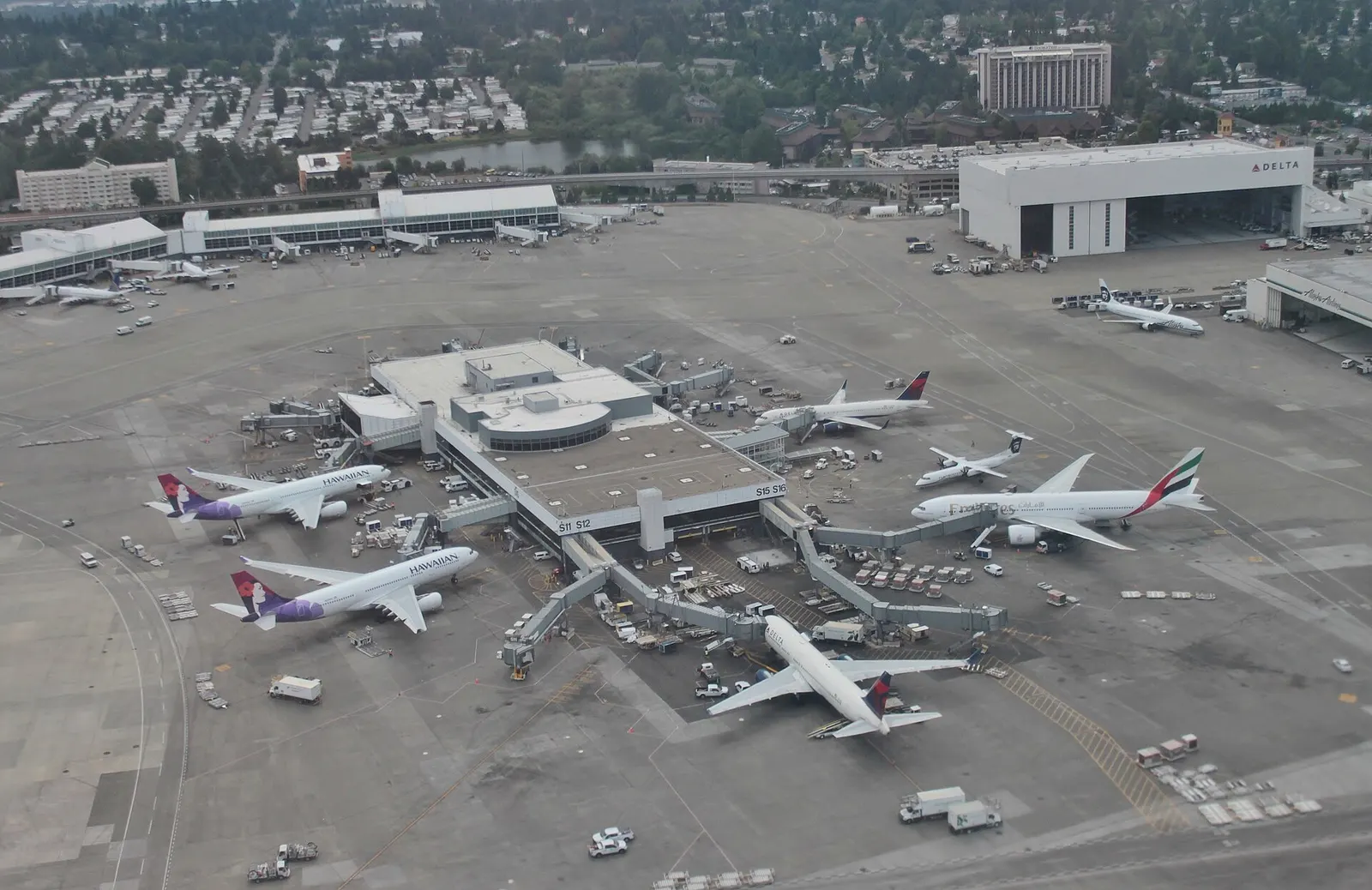 An aerial view of the South Satellite international terminal with jet bridges and aircraft at the gates.