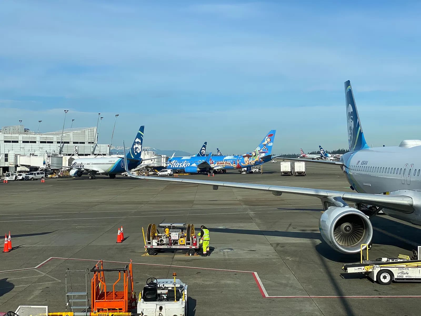 The glass-fronted main terminal at Seattle-Tacoma International Airport seen from the curbside approach in daylight.