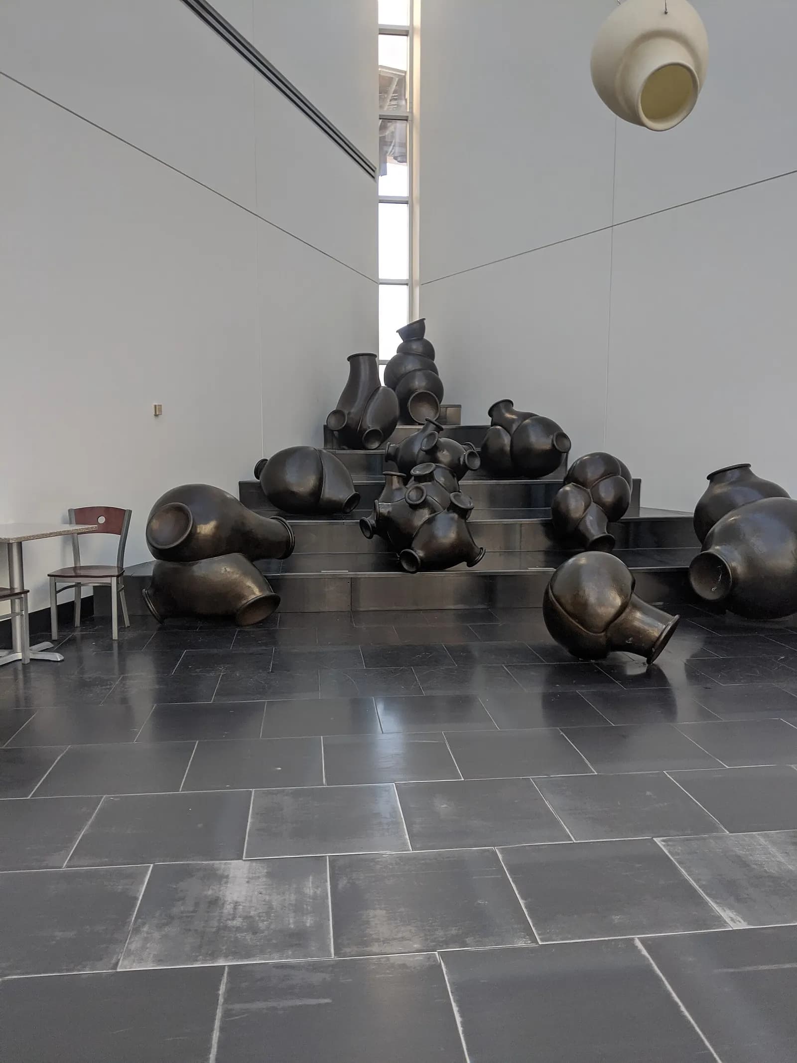 A large piece of public art installed inside the airport terminal, displayed along a passenger walkway.