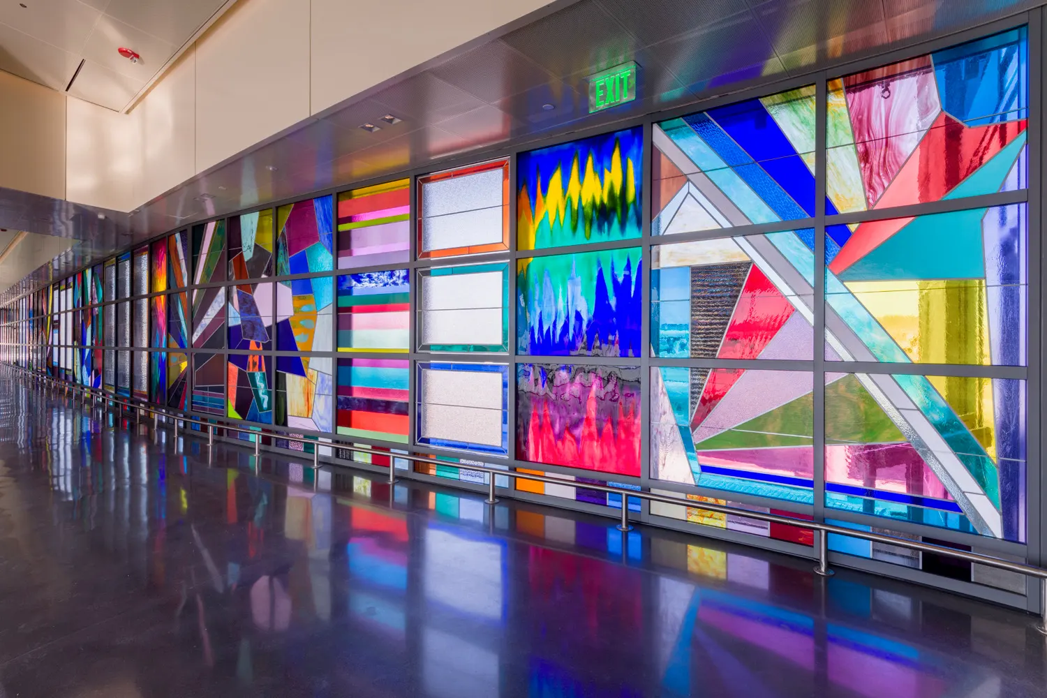 A large colorful mural by artist Sarah Cain spans a wall in a San Francisco International Airport terminal.