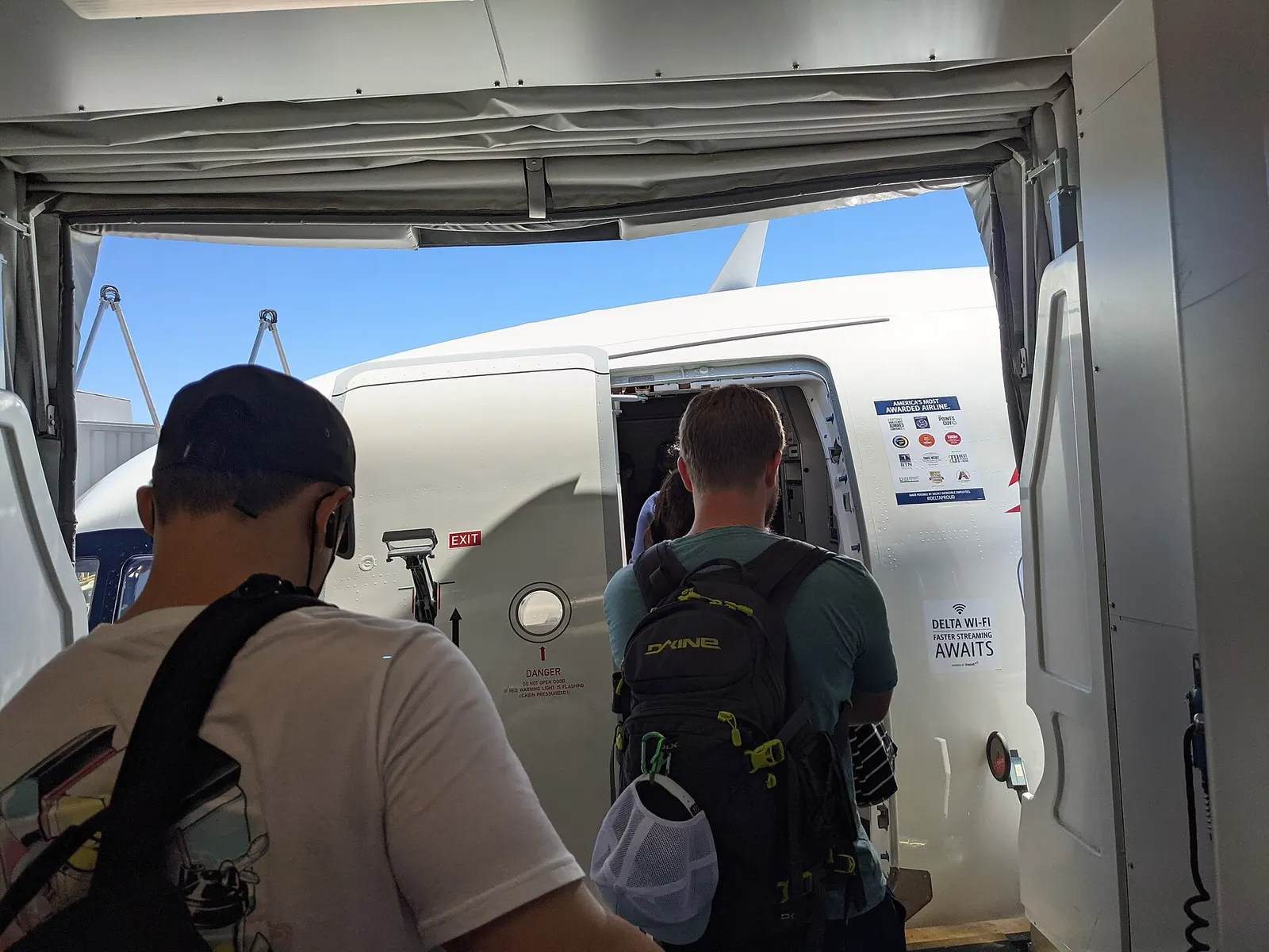 Passengers line up at a jet bridge gate to board a Delta Air Lines Airbus A321neo parked at San Francisco International Airport.