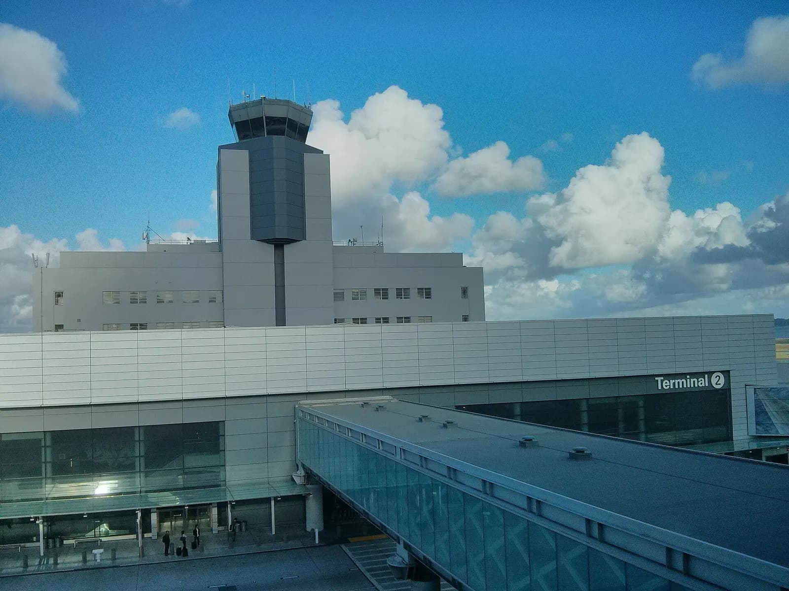 Terminal 2's curved glass facade and entrance as seen from an SFO AirTrain car riding along the elevated guideway.