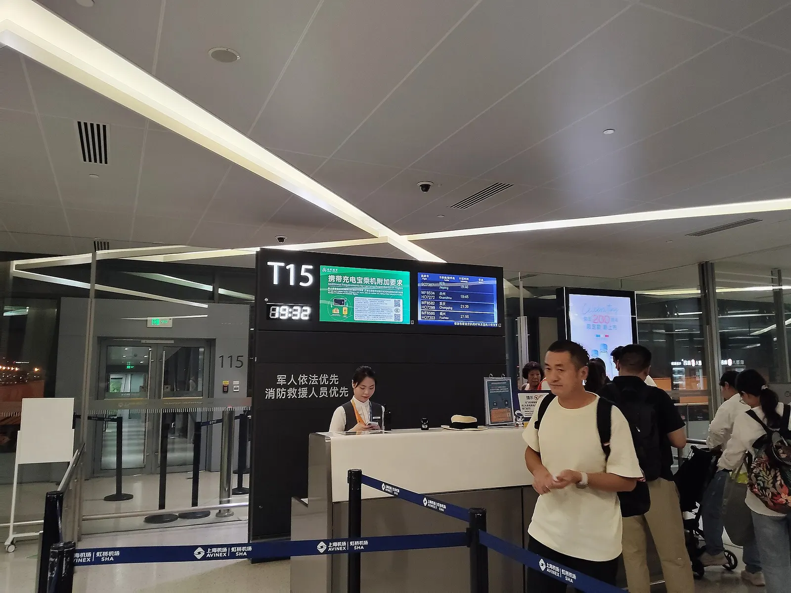Gate T15 in Terminal 1 shows a boarding sign, seated passengers in the hold room, and a jet bridge linked to a parked aircraft.