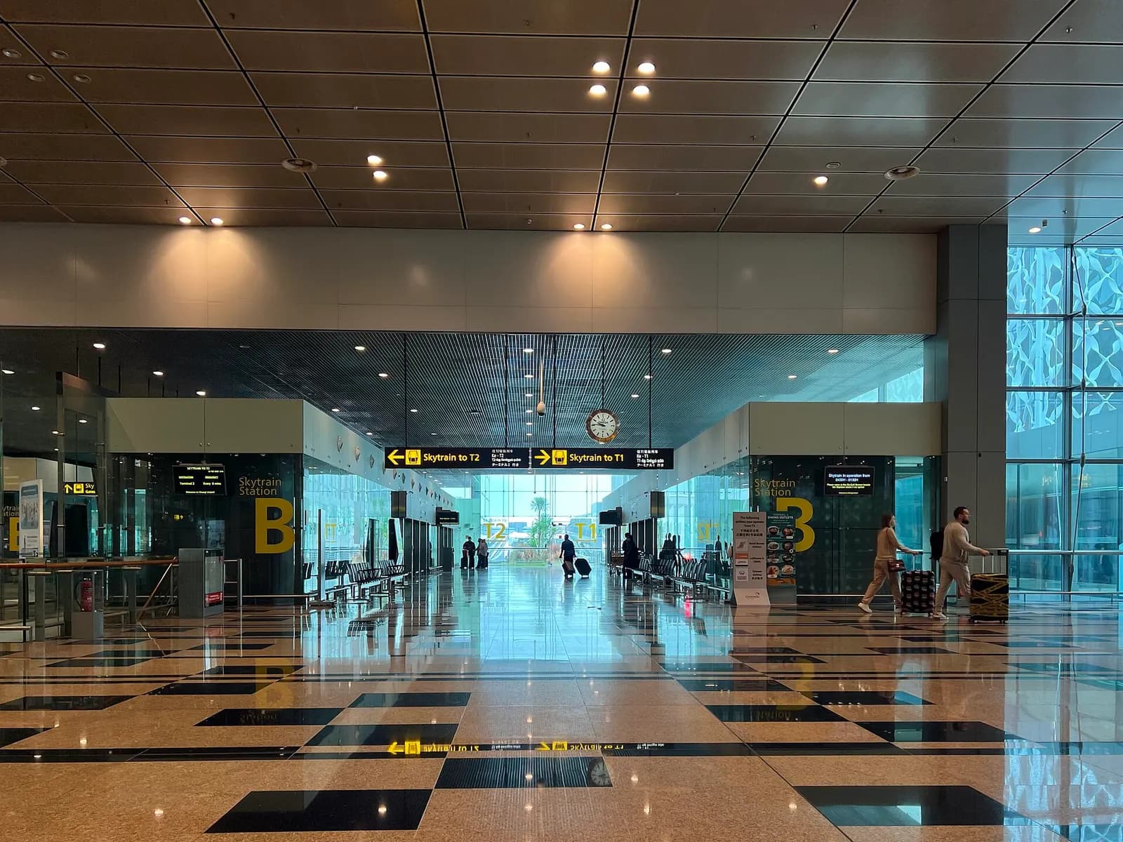 A Changi Airport Skytrain station in Terminal 3 with platform doors, route signage, and the automated people-mover visible at the track.