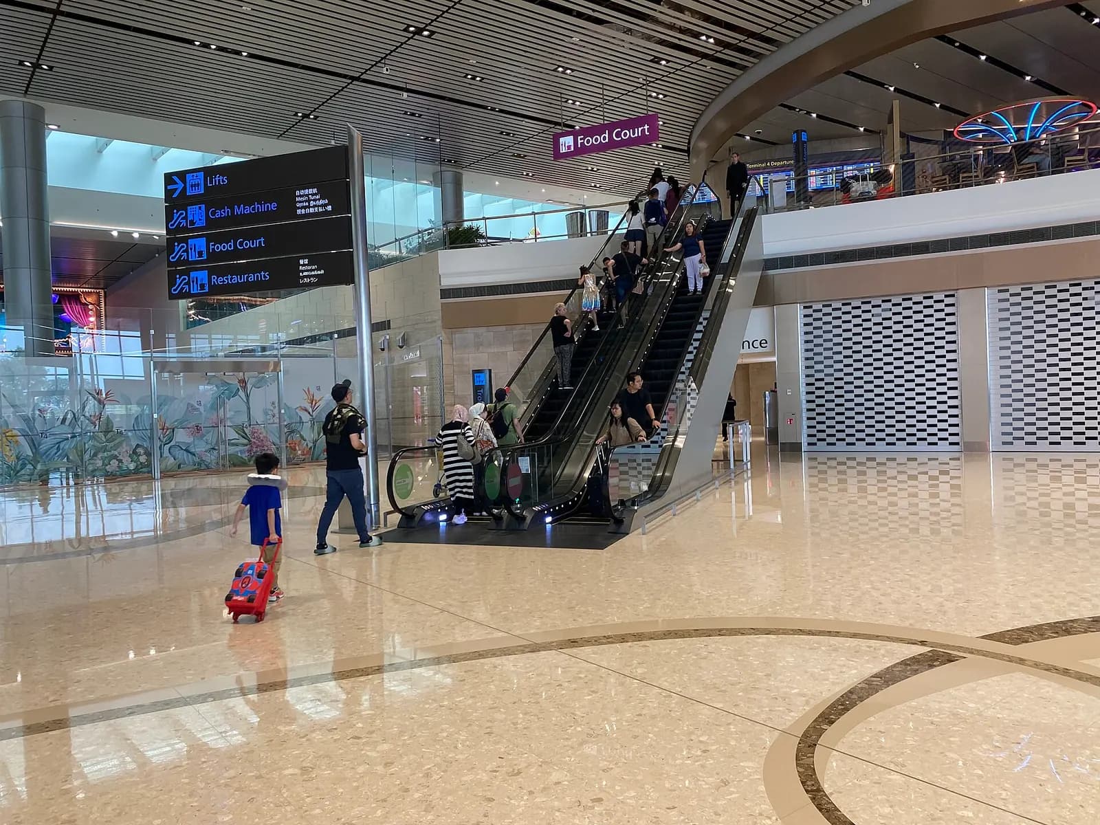 The modern interior of Singapore Changi Airport Terminal 4 with clean lines, digital displays, and passenger circulation areas.