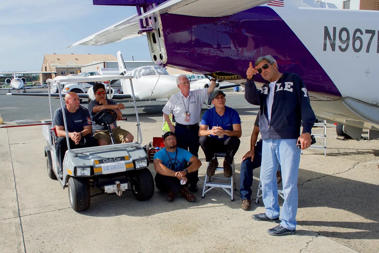 U.S. Secretary of State John Kerry speaks about his nearby plane with a group of workers waiting on the tarmac at Luis Muñoz Marín International Airport in San Juan, Puerto Rico, as he stopped on August 3, 2016, en route from Washington, D.C., to Buenos Aires, Argentina, and Rio de Janeiro, Brazil. 