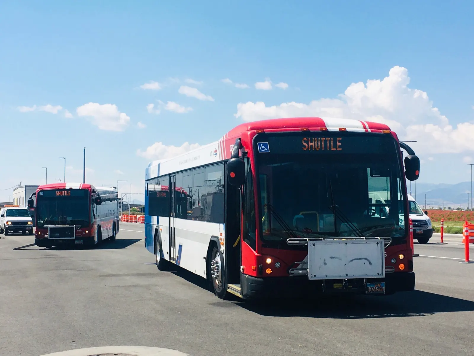 A UTA airport shuttle bus in the ground transportation area near the terminal.
