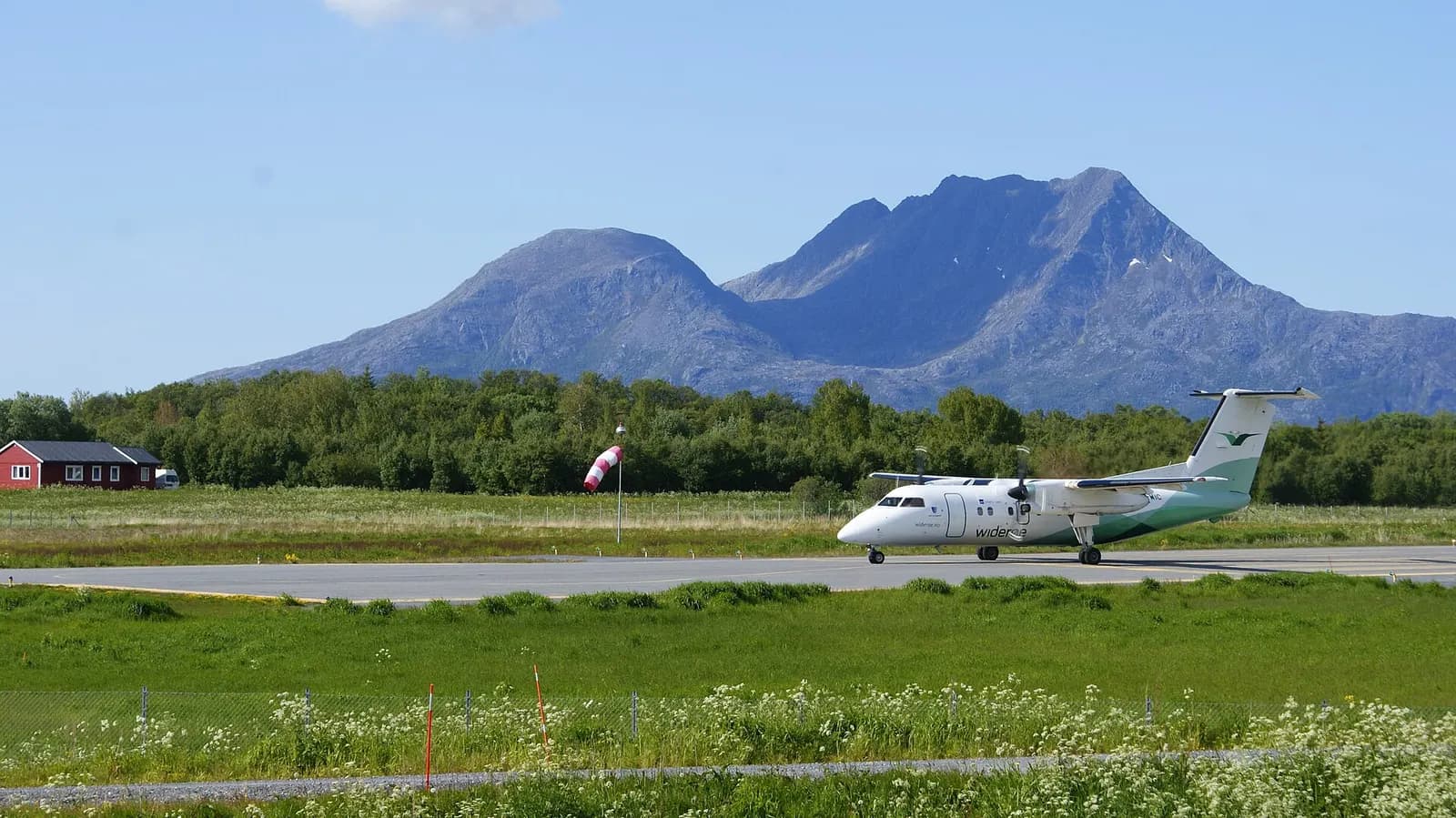 Widerøe de Havilland Canada Dash-8 103 taxiing before takeoff at Sandnessjøen Airport, Alsten, Helgeland, Nordland, Norway. Dønnmannen mountain in the background.