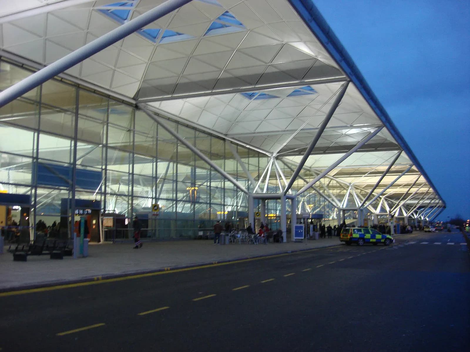 The glass-fronted main terminal building at London Stansted Airport viewed from the forecourt.