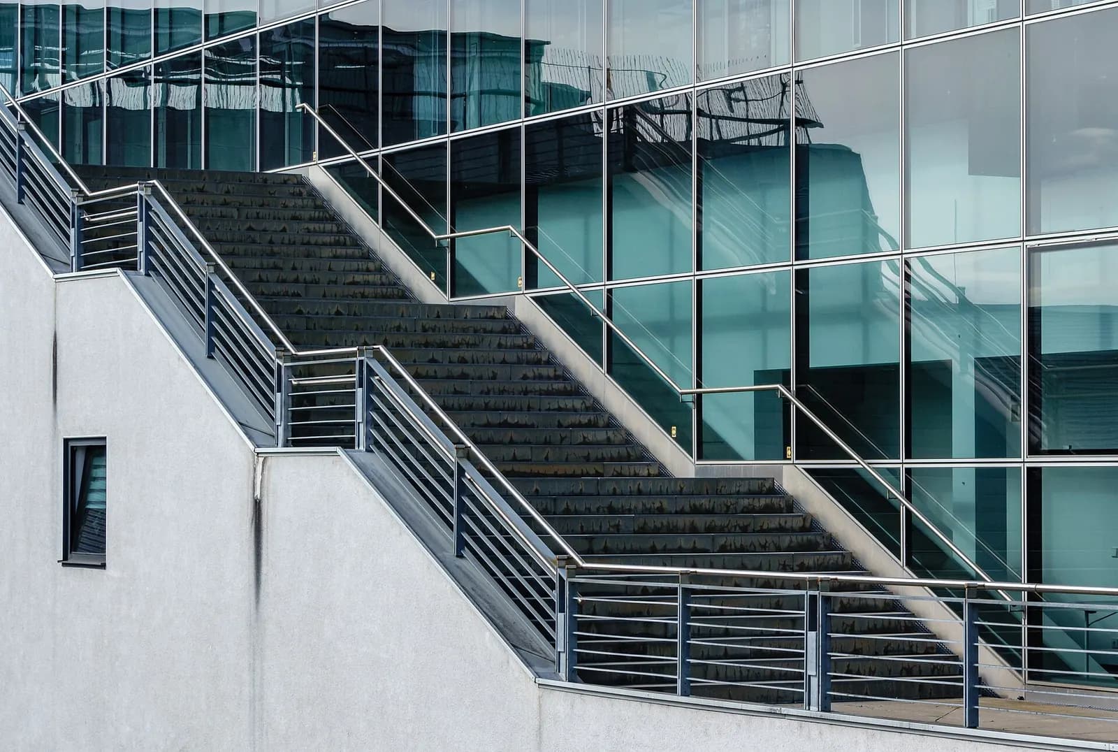 Outdoor stairs and the modern facade of Terminal 3 at Stuttgart Airport on a clear day.