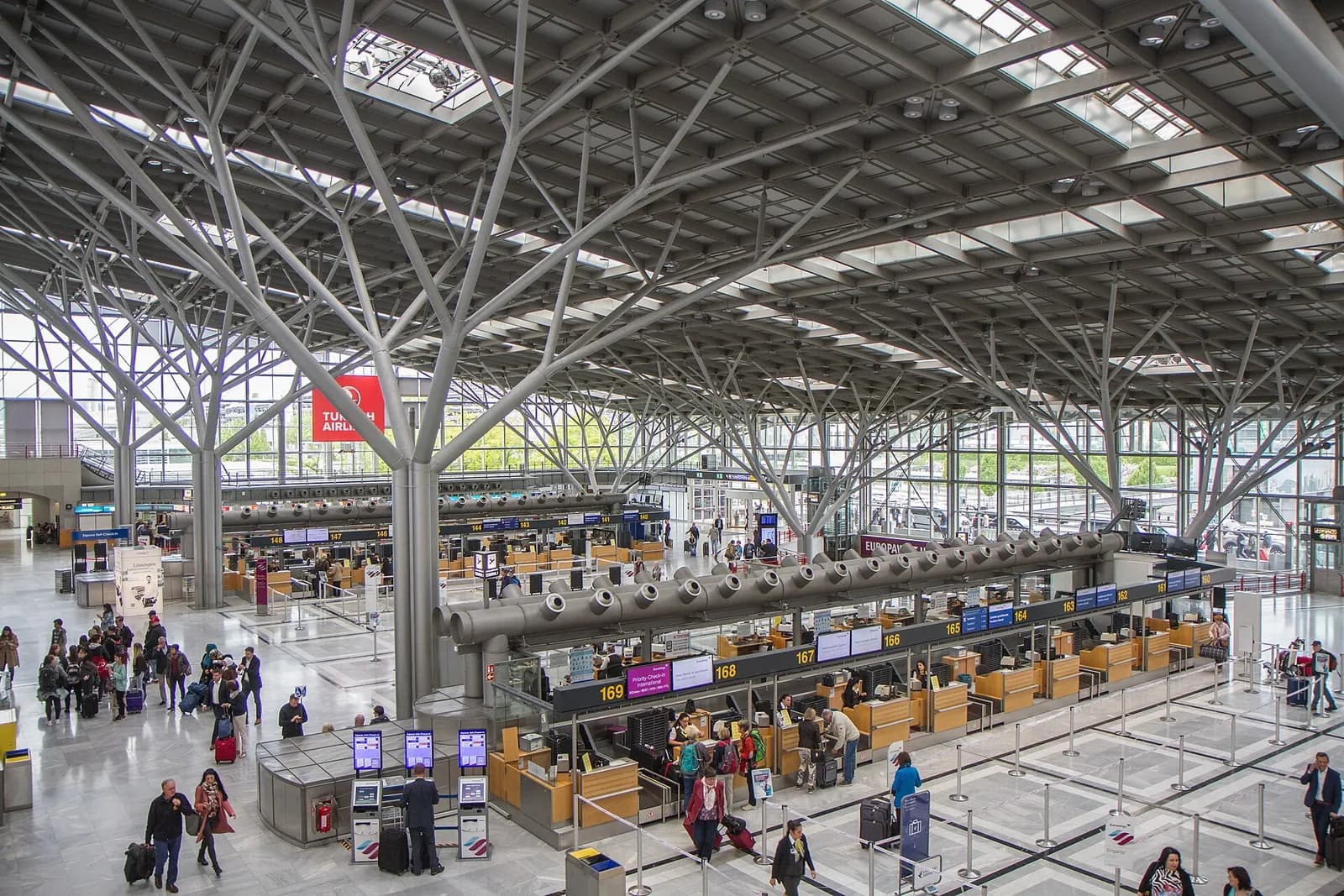 The glass-fronted Terminal 1 at Stuttgart Airport with its distinctive tree-like white support columns and departure hall canopy.