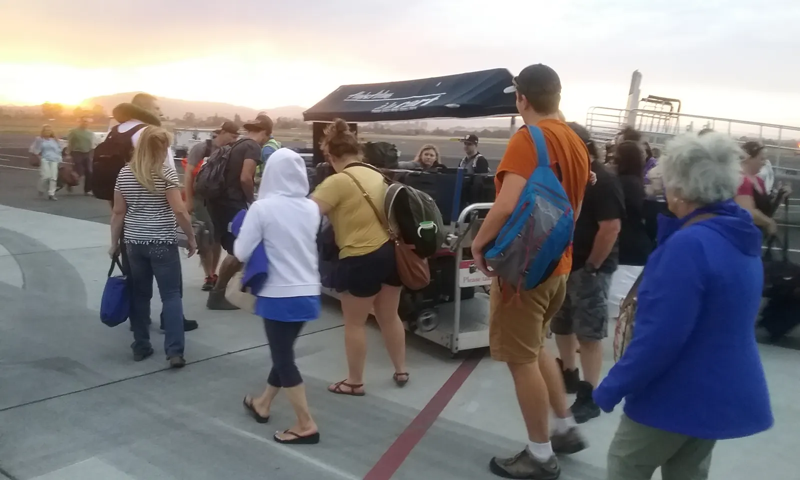 Passengers collecting bags from a cart at STS after a Horizon Air Q400 arrival on 11 September 2017. Historic ramp scene versus the 2023 hall.
