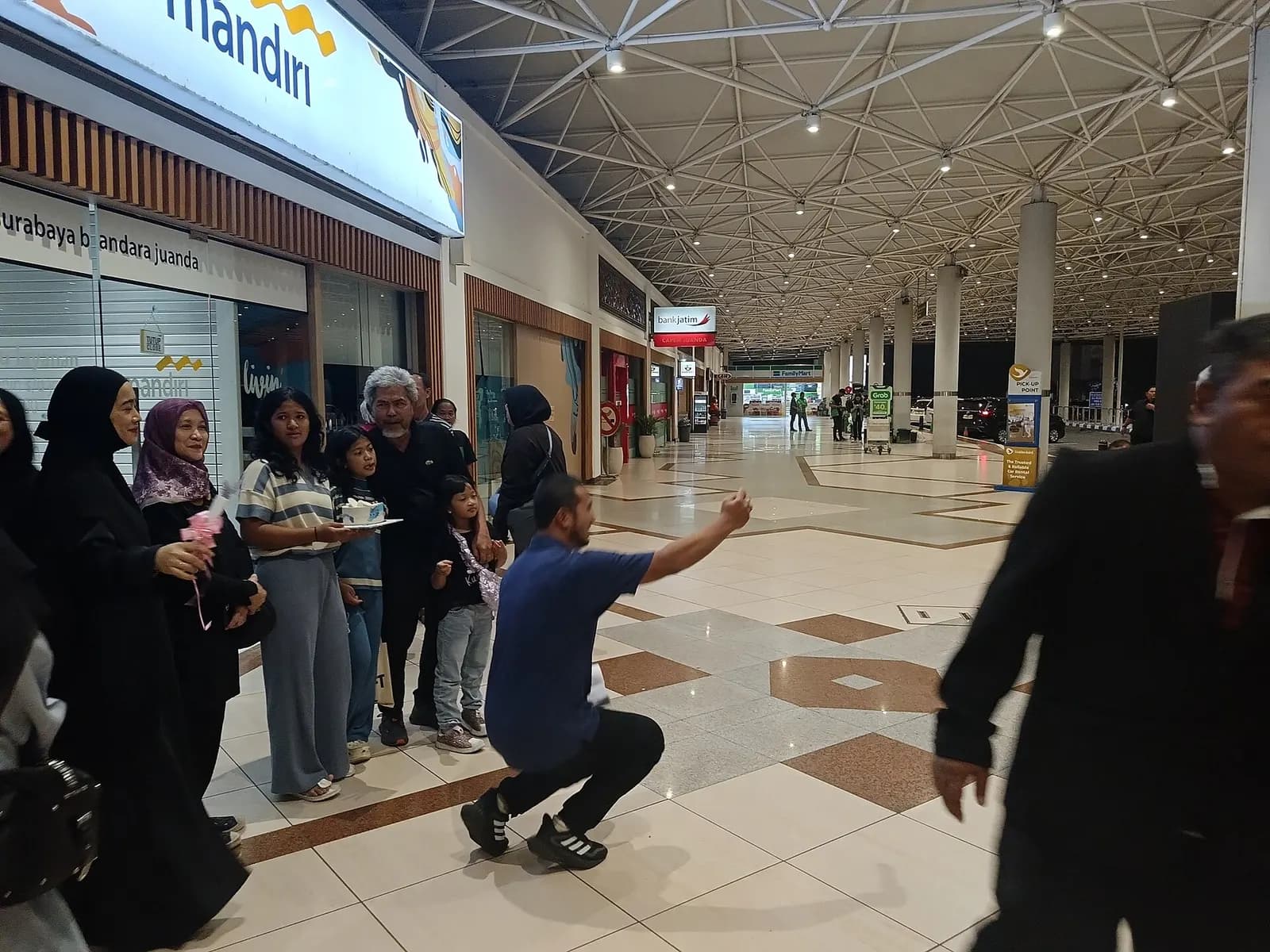 Landside concourse at Juanda International Airport with Surabaya Bandara Juanda signage, Bank Mandiri, and FamilyMart