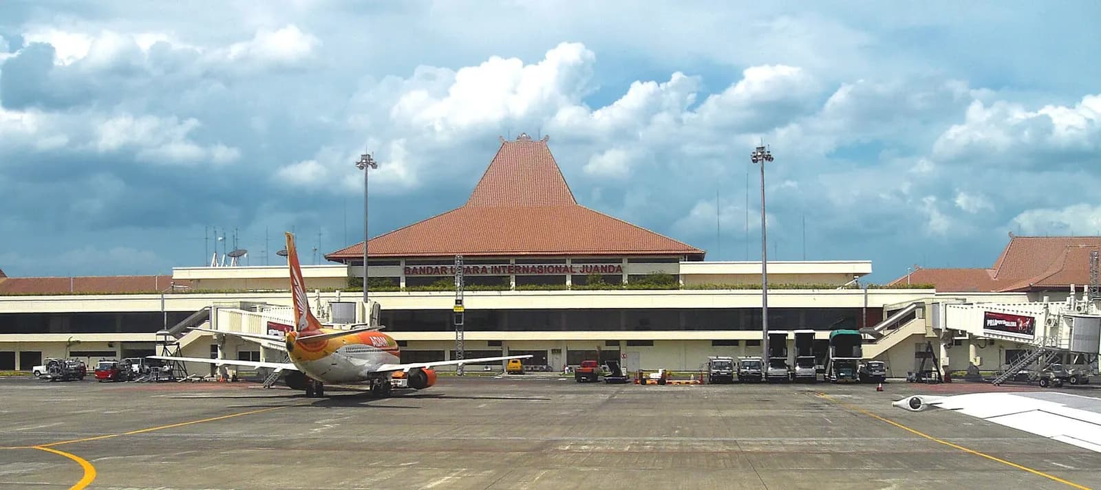 Exterior of Juanda International Airport Terminal 1 with joglo-style roof and apron view