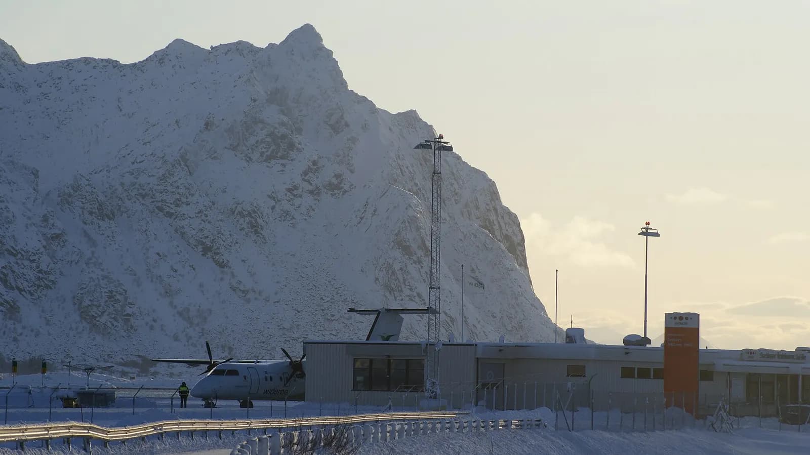 Widerøe Dash 8 parked at Svolvær Airport, Helle with Litlmolla beyond