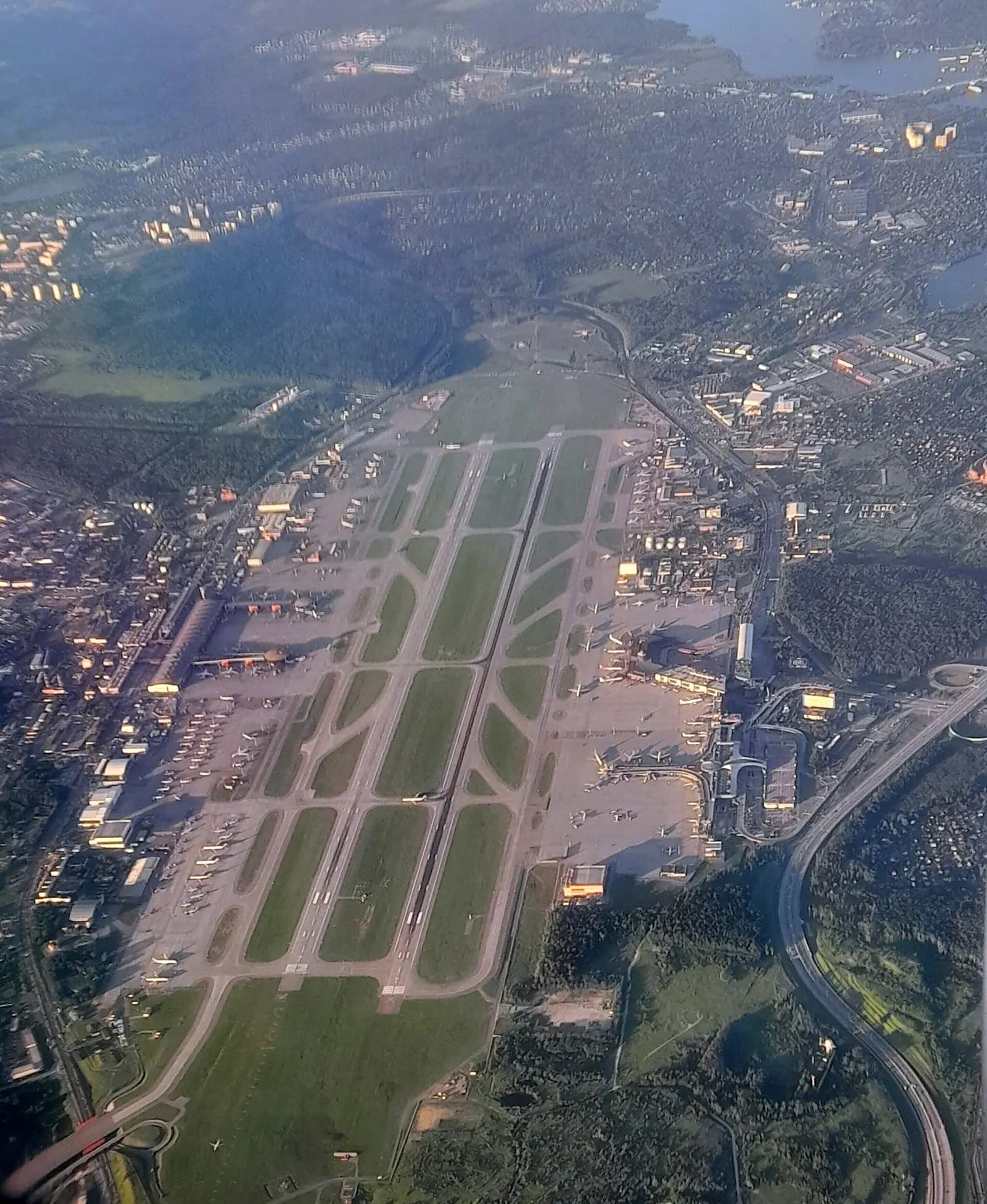 Aerial view from an aircraft showing Sheremetyevo's parallel runways, terminal complexes, and forested countryside northwest of Moscow.