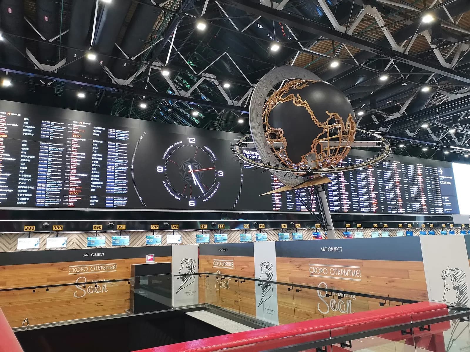 Check-in hall in Terminal C with airline counters, queue stanchions, and overhead departure information screens.