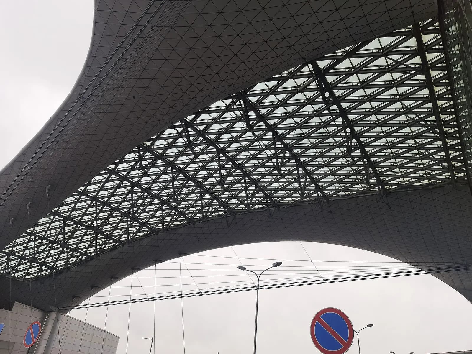Terminal D building seen from outside on a clear day, with its distinctive architecture and apron area in view.