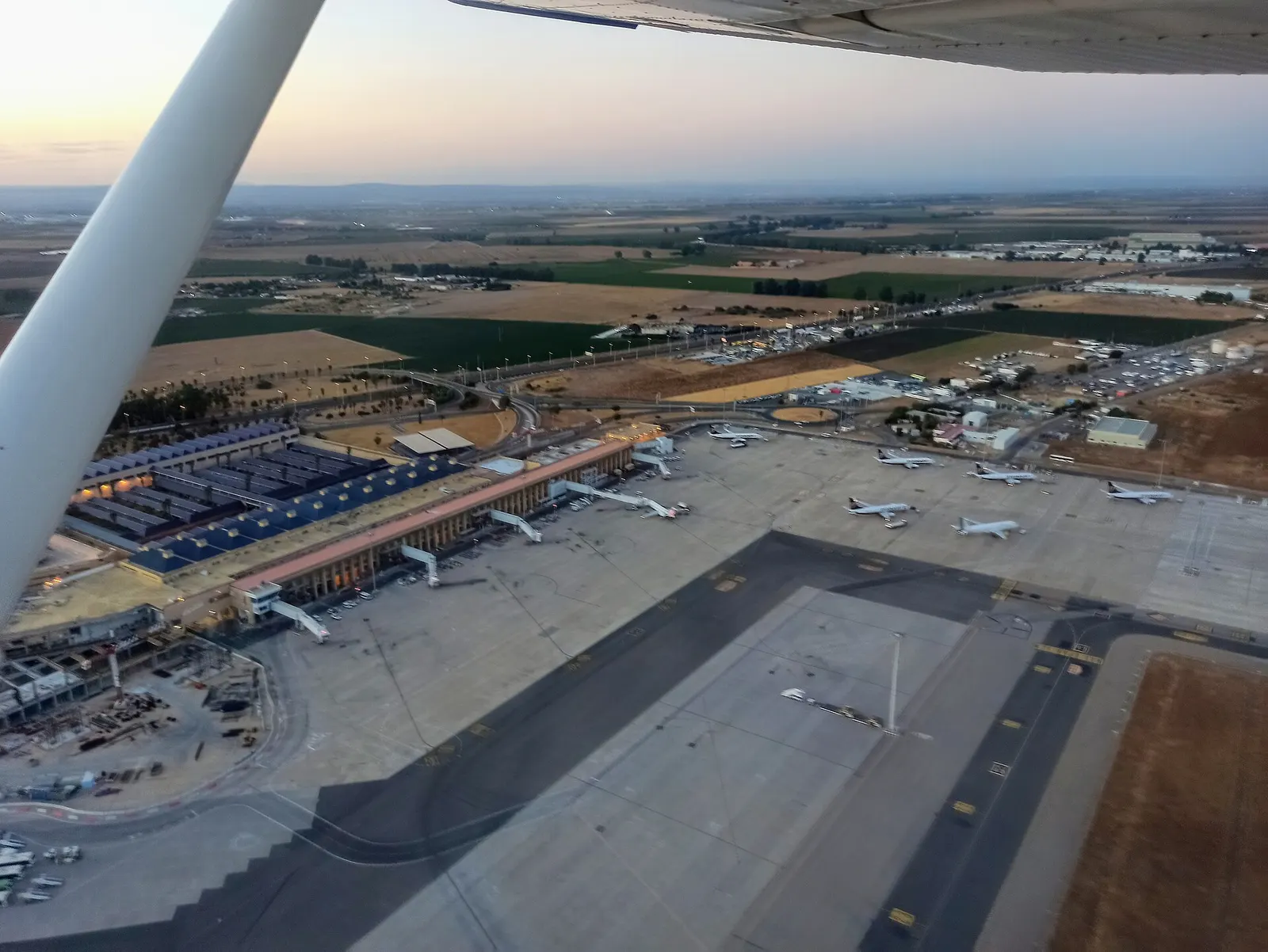 Aerial view of Seville Airport terminal, apron and runway.