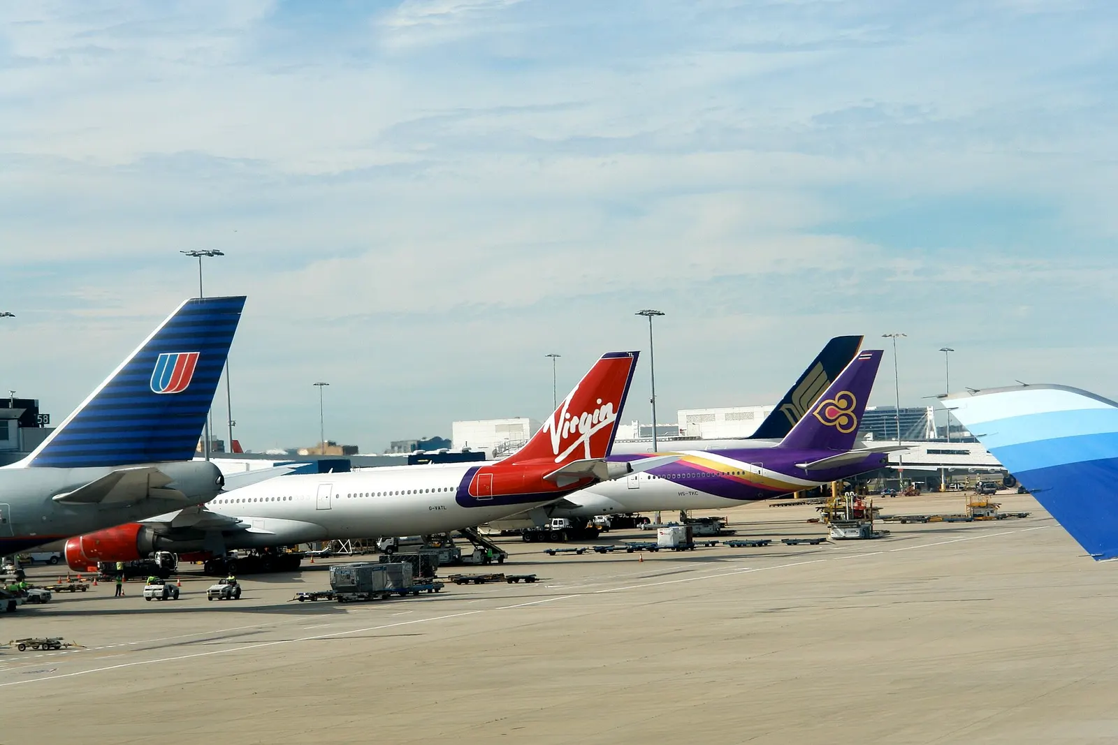 Check-in counters for United, Virgin Australia, and Thai Airways line the international departures hall.