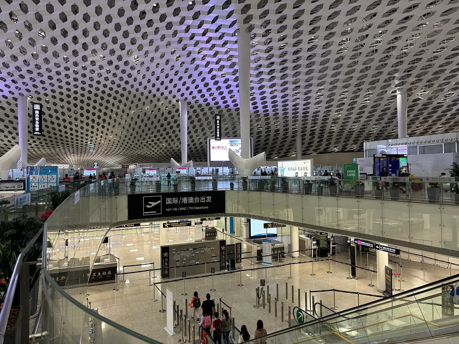 International departure entrance on the fourth floor of Terminal 3, with passport control lanes, signage, and passengers heading toward immigration.