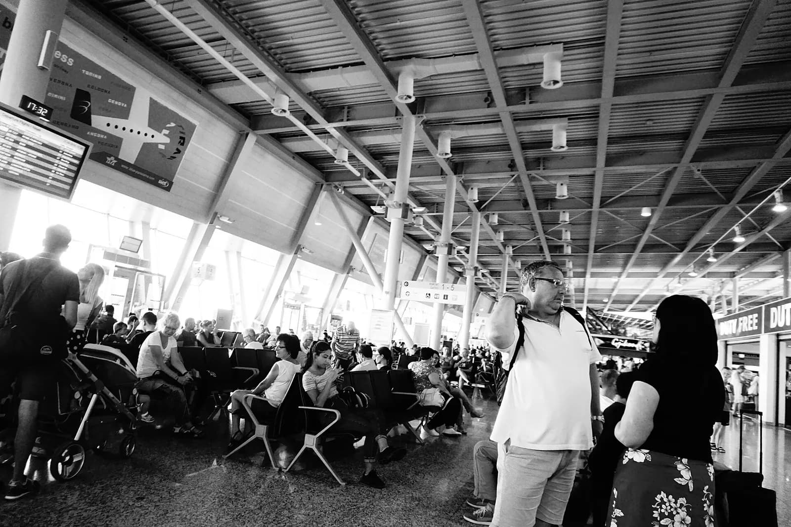 Airside gate waiting area at Tirana International Airport looking toward large terminal windows