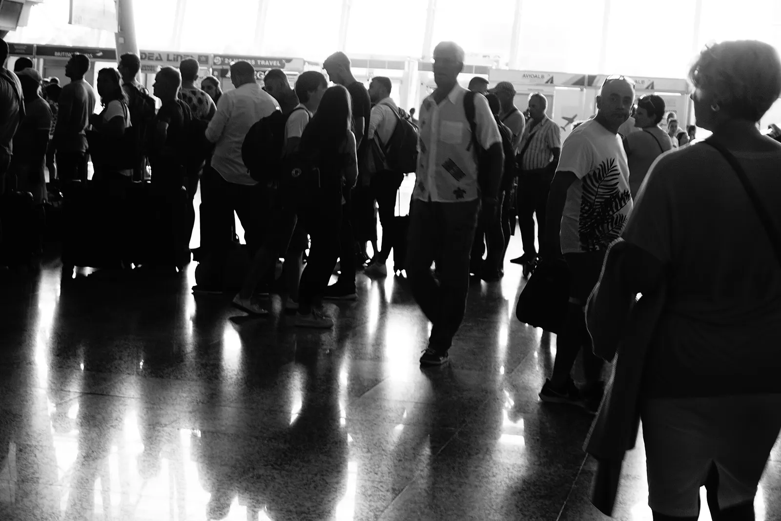 Busy check-in hall at Tirana International Airport with passengers queuing at airline desks